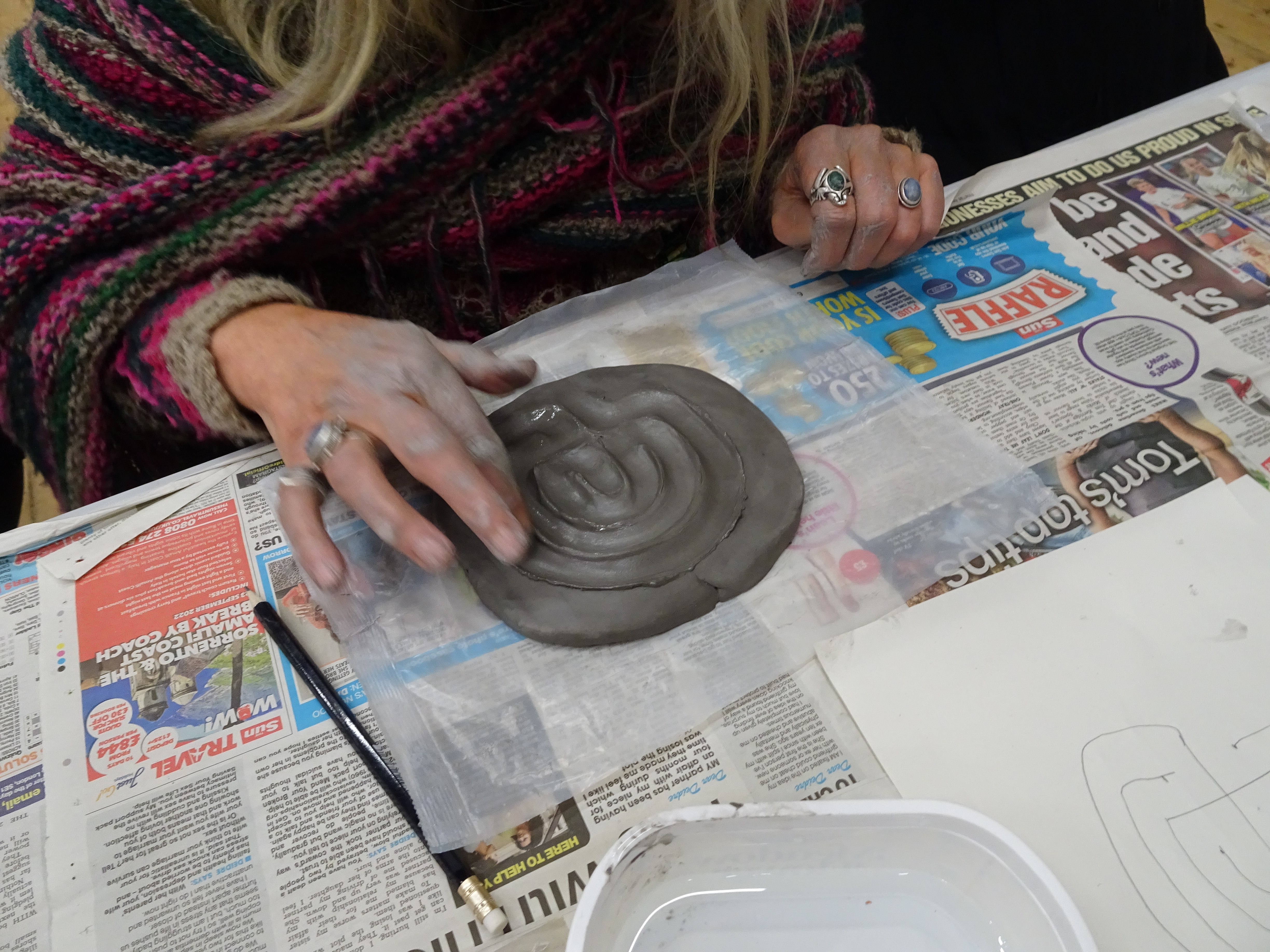 Finishing off a labyrinth - making a smooth channel in the clay with a finger.