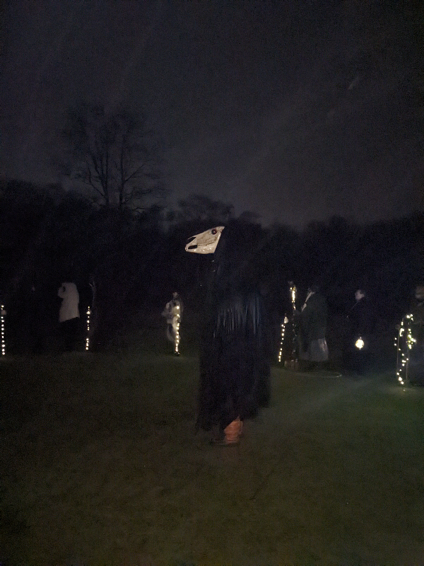 The Ickeny, with horse's skull glistening from the rain, stands in the centre of the circle, with officers standing behind with lit posts, at the end of the rite.