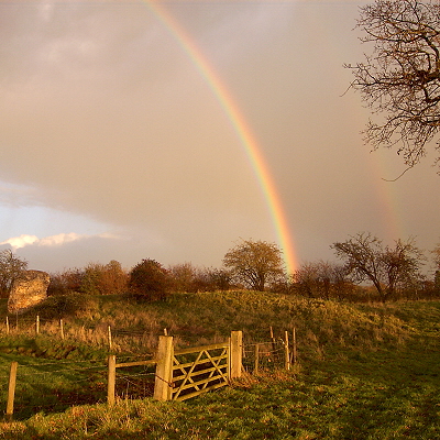 Rainbow at Venta Icenorum, over the bank wall, with a flint turret to the left.